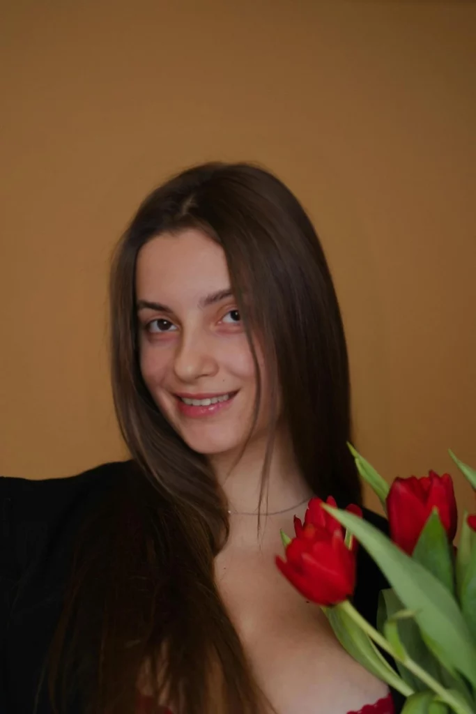 Immagine felice di una giovane ragazza che tiene in mano dei fiori