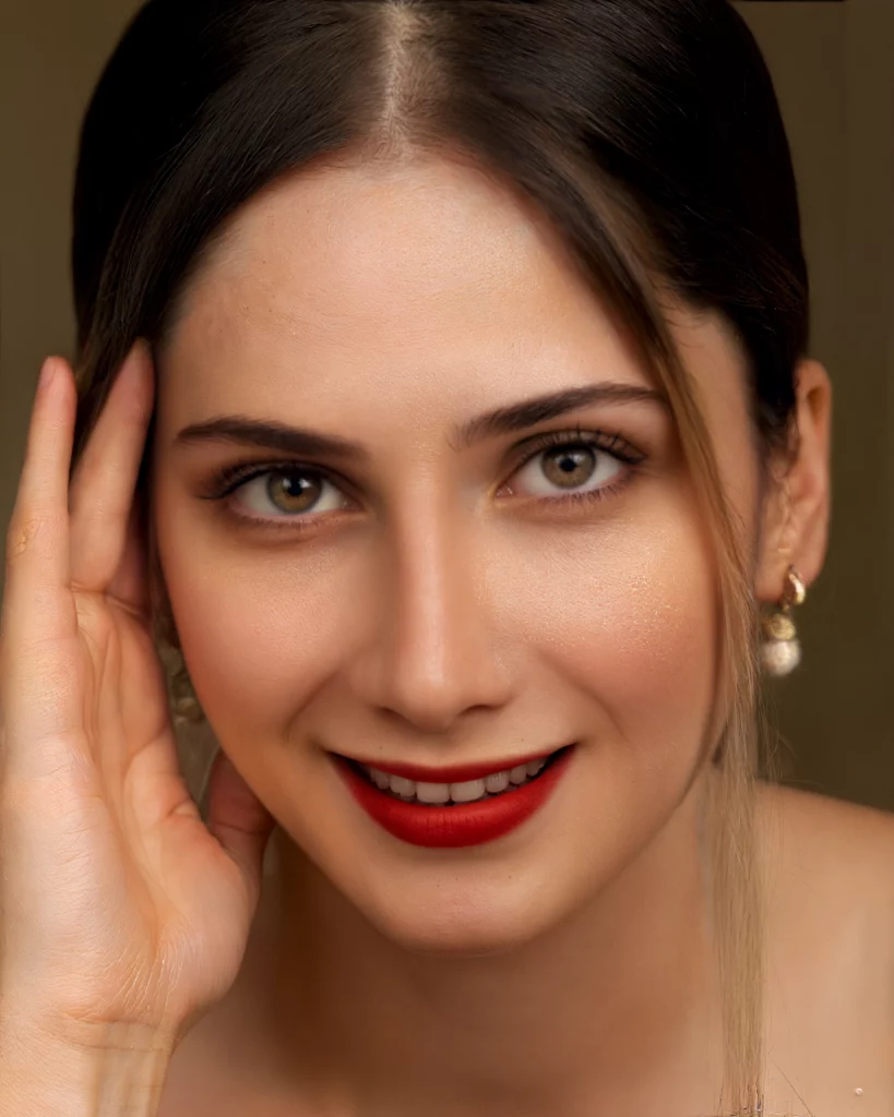 Immagine migliorata di una donna sorridente con capelli neri e rossetto rosso