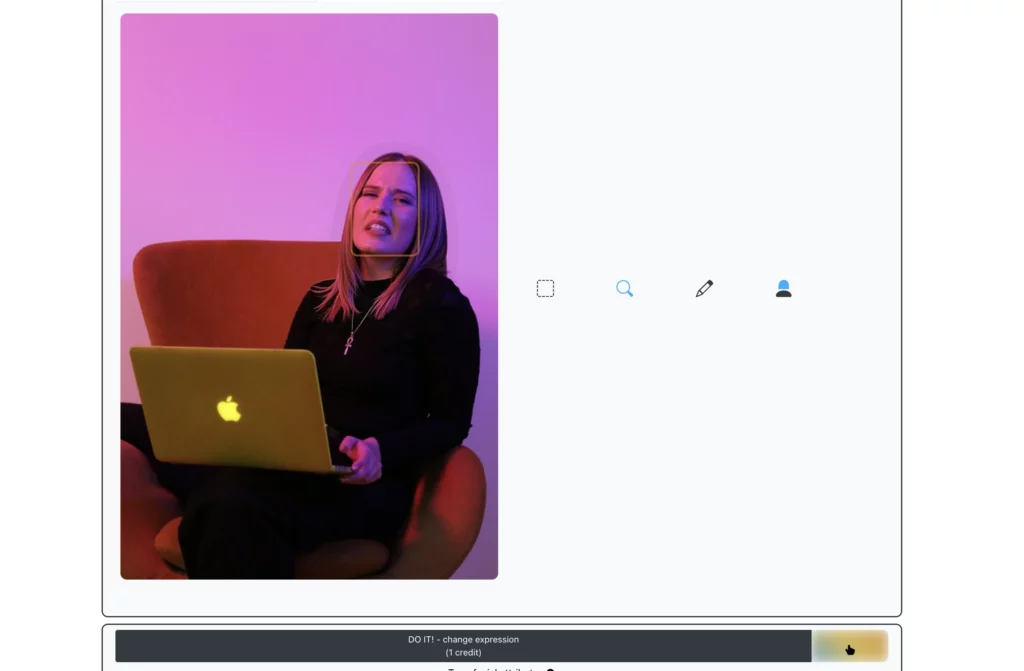 Una donna dai capelli lunghi è seduta su una sedia arancione con in mano un portatile Apple giallo, e sorride dopo aver usato EraseID. Lo sfondo è illuminato da sfumature rosa e viola.